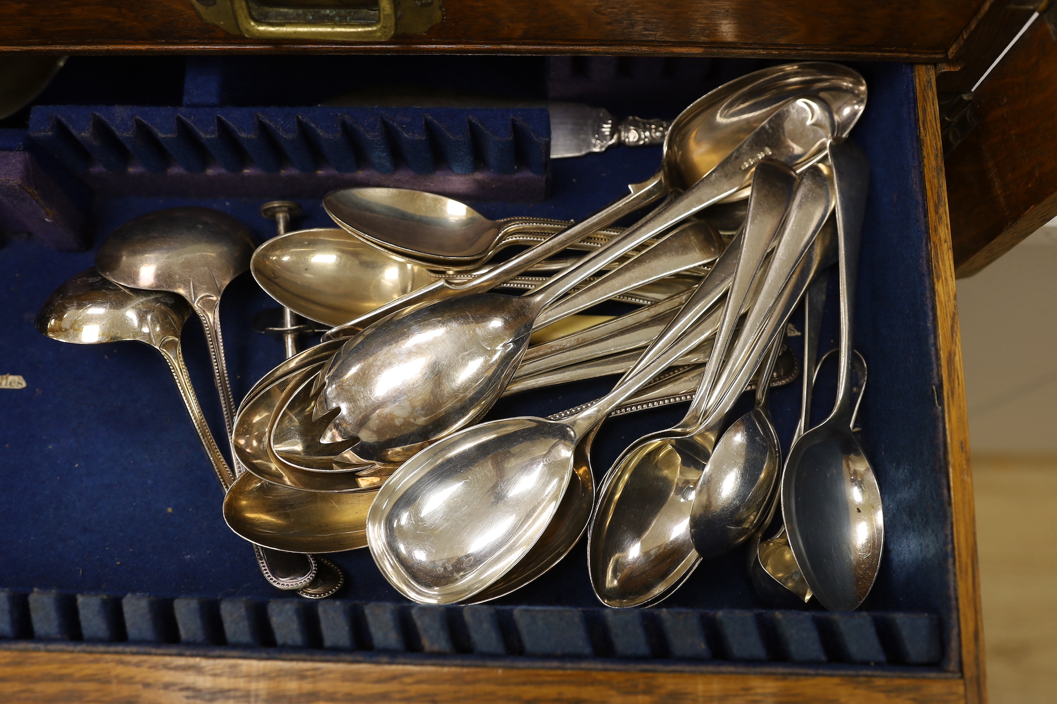 An oak part canteen of beaded Old English pattern flatware